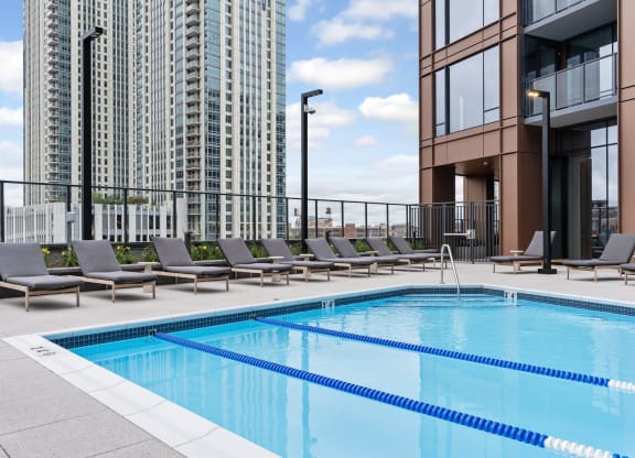 a swimming pool on the rooftop of a building with lounge chairs at Cassidy on Canal, Chicago, IL, 60654
