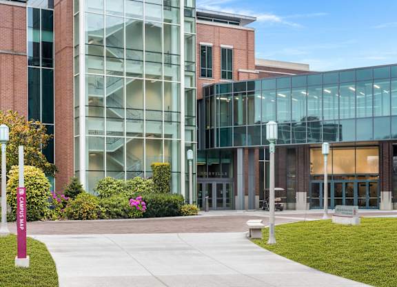 a sidewalk in front of a building with glass windows