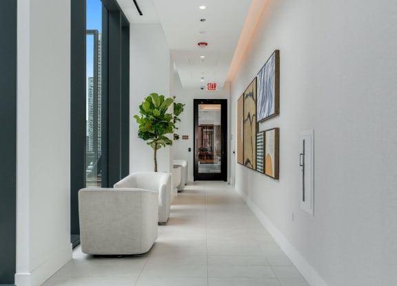 a long hallway with white walls and white chairs and a plant  at Cassidy on Canal, Chicago, Illinois