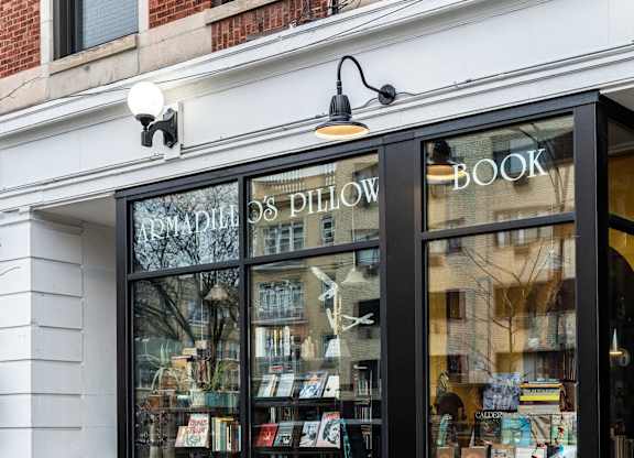 the front of a bookstore with books in the window