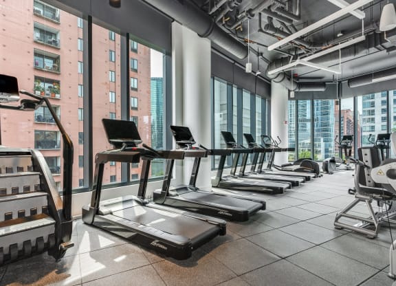 a row of treadmills in a fitness room with a view of the city  at Cassidy on Canal, Chicago, Illinois