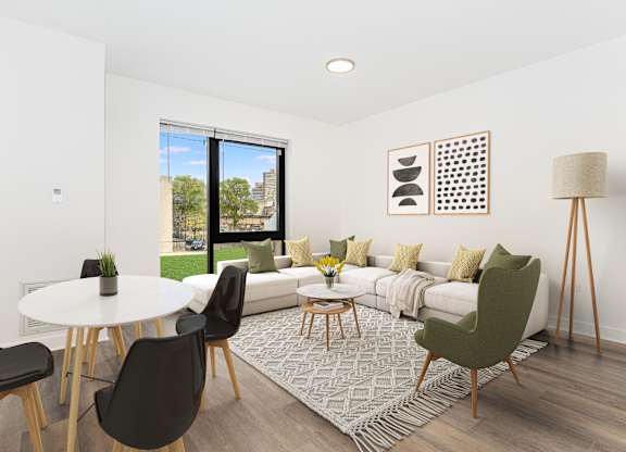 A living room with a white couch, a white table, and a green chair.