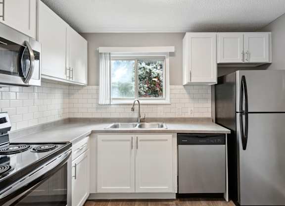 Modern kitchen with white cabinets and stainless appliances1 at Cedarvale Highlands Apartments, Eagan, Minnesota