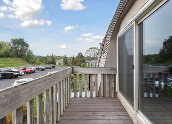 Apartment balcony with wooden railings overlooking parking at Cedarvale Highlands Apartments, Minnesota