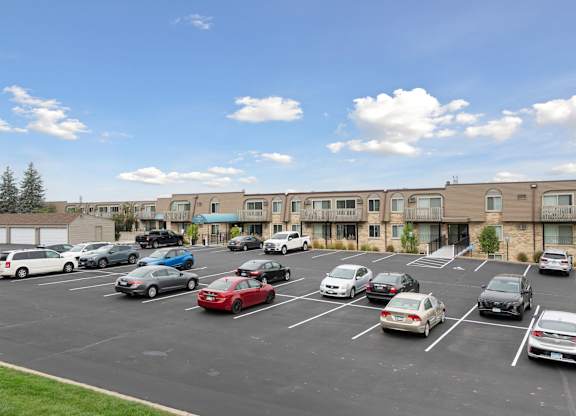 Parking lot with resident vehicles and apartment buildings at Cedarvale Highlands Apartments, Eagan, MN