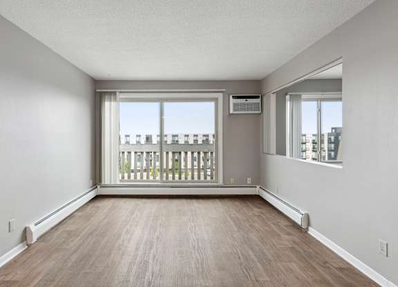 Empty living room with large windows at Cedarvale Highlands Apartments, Eagan, Minnesota