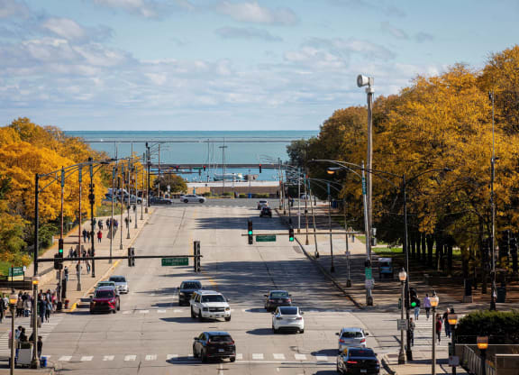 a city street with cars driving down it and the ocean in the distance at Columbus Plaza, Chicago, 60601