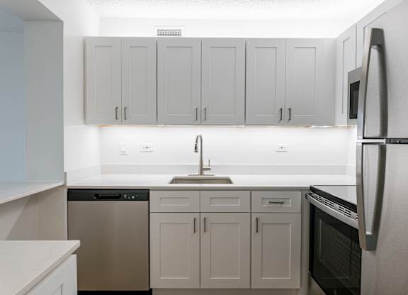 A kitchen with white cabinets and appliances at Columbus Plaza, Illinois, 60601