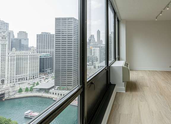 A room with a large window overlooking a river and city buildings at Columbus Plaza, Chicago, Illinois