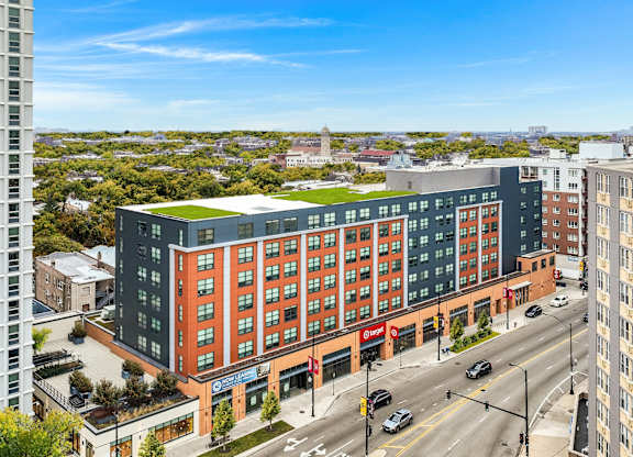 a large building with a green roof on a city street