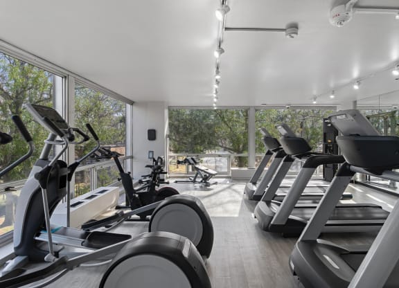 a gym with treadmills and other cardio equipment in a building with large windows at The Pavilion, Michigan, 48207