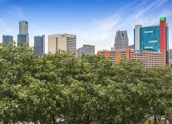 a city skyline with trees in the foreground at The Pavilion, Detroit, MI, 48207