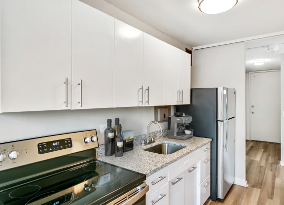a kitchen with white cabinets and stainless steel appliances at The Pavilion, Detroit, MI