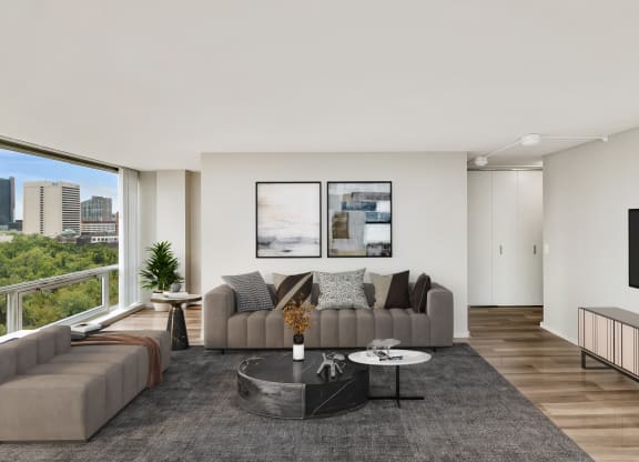 a living room with white walls and a large window with a city view at The Pavilion, Detroit, MI, 48207