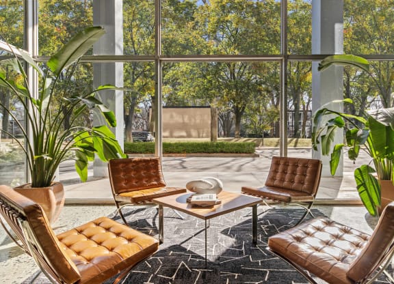 a living room with brown leather chairs and a table at The Pavilion, Detroit, 48207