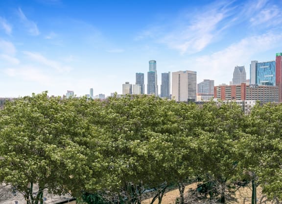 a city skyline with trees in the foreground at The Pavilion, Detroit, MI