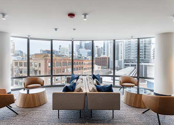 A modern living room with a view of the cityscape outside the large windows at Kingsbury Plaza, Chicago, IL