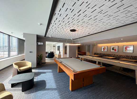 A room with a pool table and a shuffleboard table at Kingsbury Plaza, IL, 60654