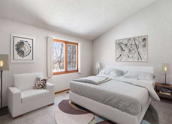 a bedroom with a bed and a chair and a window at Seasons Villas, Woodbury, MN