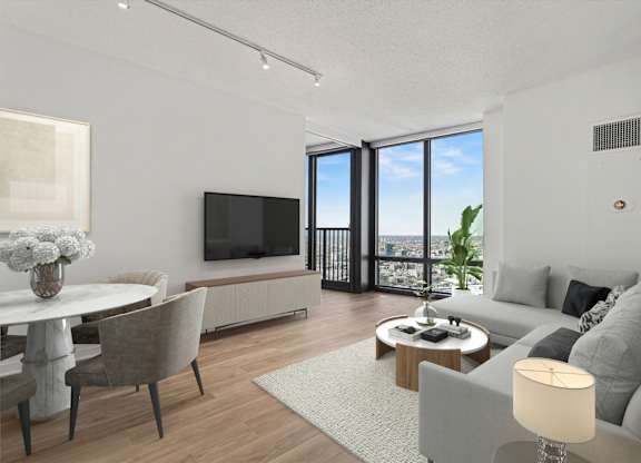 A modern living room with a grey sofa, a white coffee table, and a flat screen TV.
