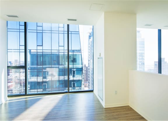 an empty room with white walls and floor to ceiling windows with a view of the city at One 333, Chicago, 60605