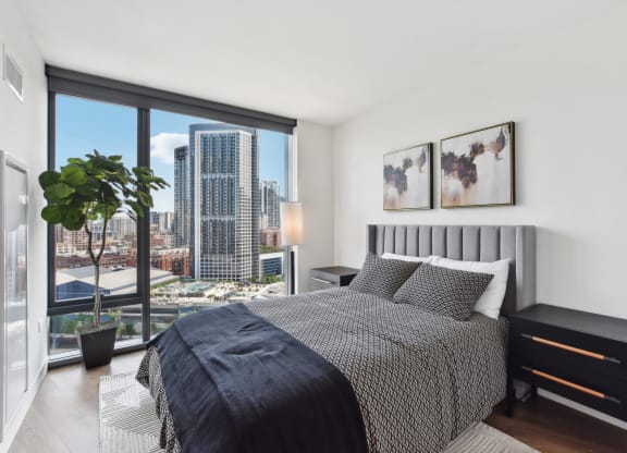 a bedroom with a bed and a large window and a view of the city at Cassidy on Canal, Chicago, IL