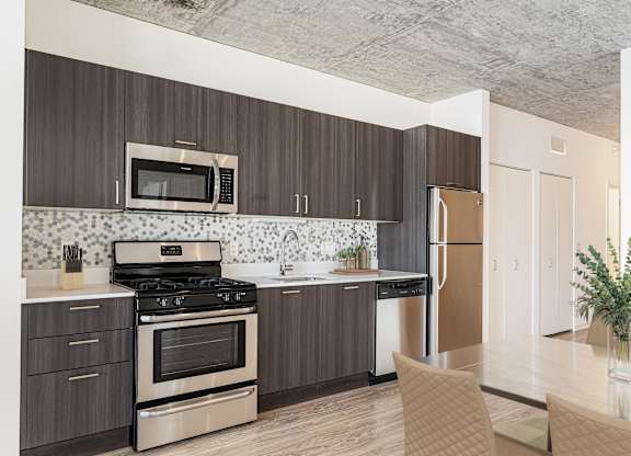 A kitchen with a stove, oven, microwave, and refrigerator.