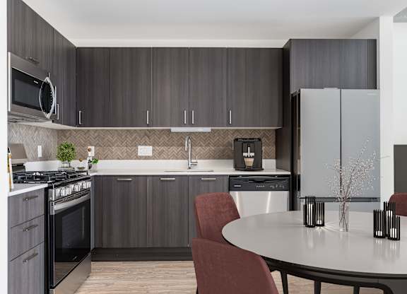 A modern kitchen with a round table and chairs.