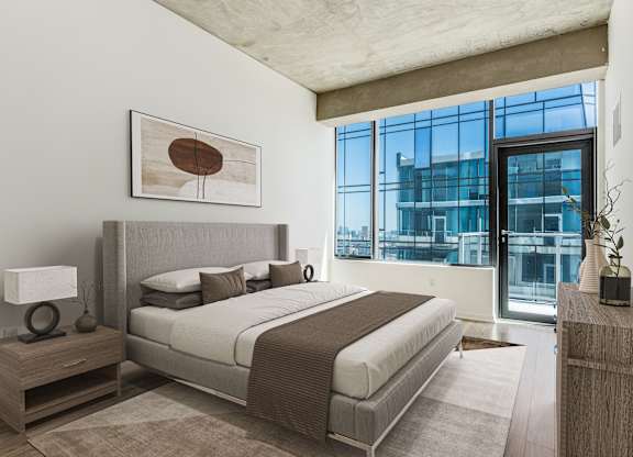 A bedroom with a large bed and a large window.