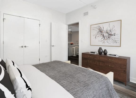 a bedroom with a bed and a dresser and a painting on the wall