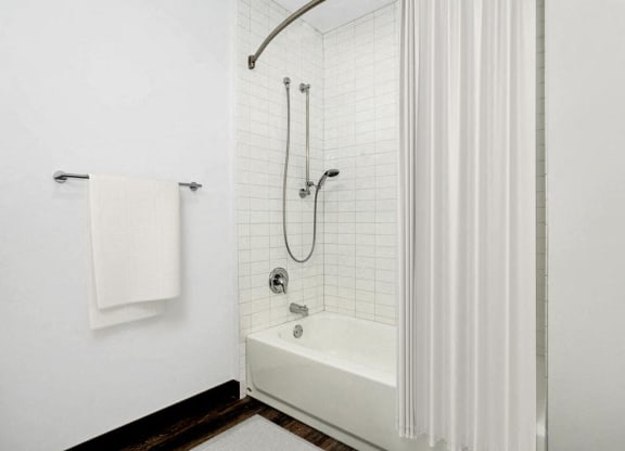 a white bathroom with a shower and a tub
