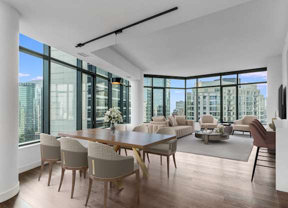 a large living room with a large table and chairs and a view of the city at Cassidy on Canal, Chicago, IL