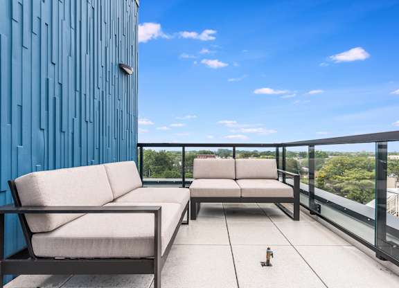 a balcony with two couches and a view of a city