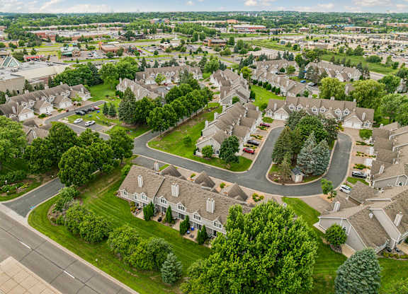A bird's eye view of a residential neighborhood with houses and greenery at Seasons Villas Apartments, Minnesota