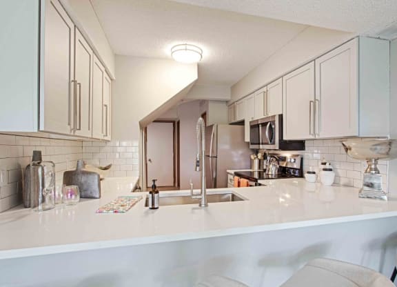 a kitchen with a counter top and a sink at Seasons Villas, Woodbury, MN 55125