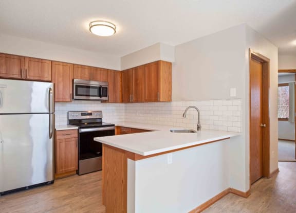 a kitchen with a white counter top and a refrigerator at Seasons Villas, Woodbury, 55125