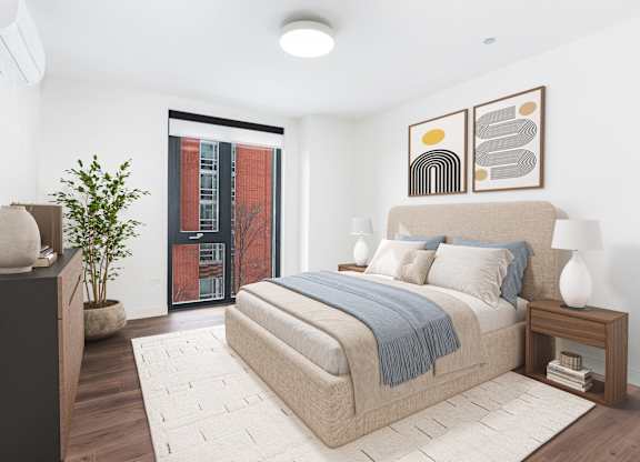 A bedroom with a large bed and a potted plant.