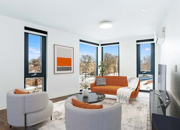 A living room with a grey sofa, orange couch, and a coffee table.