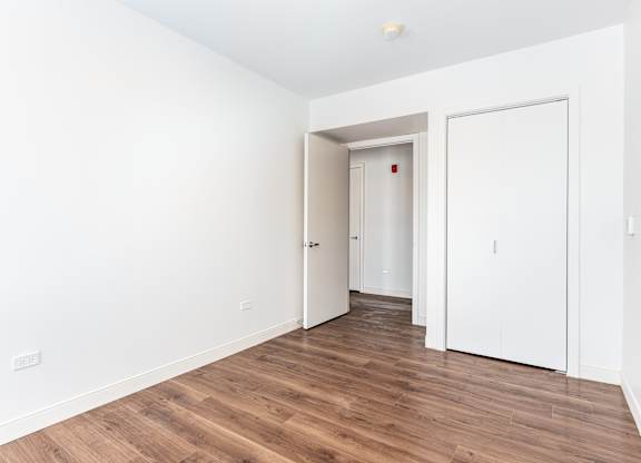 A room with a white door and a white wall.