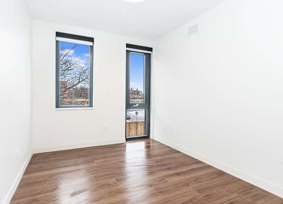A room with a wooden floor and a picture on the wall.