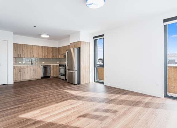 A kitchen with wooden floors and a large window.