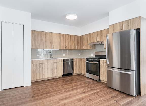 A modern kitchen with wooden cabinets and stainless steel appliances.
