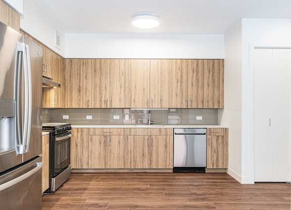 A modern kitchen with wooden cabinets and stainless steel appliances.
