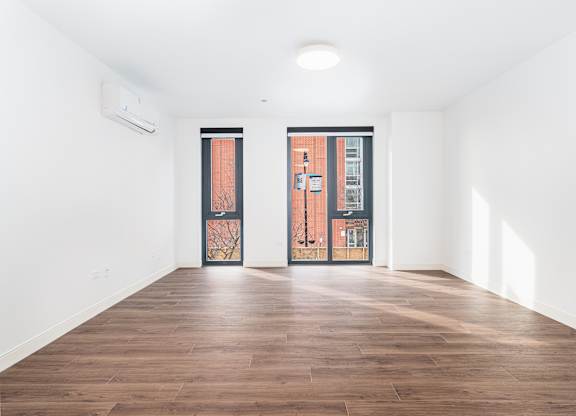 A room with a wooden floor and two doors.