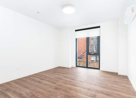 A room with wooden flooring and a sliding glass door.