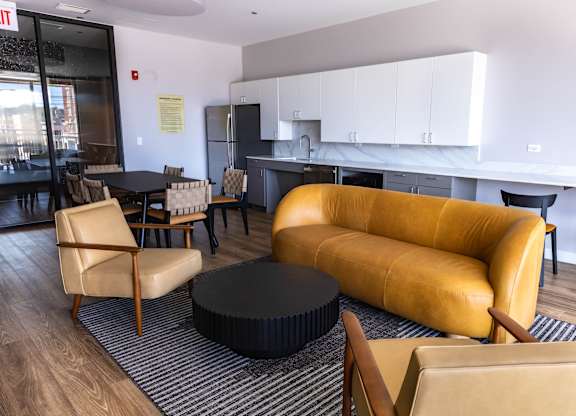Resident lounge with kitchen and seating area at Thrive Exchange Apartments, Illinois