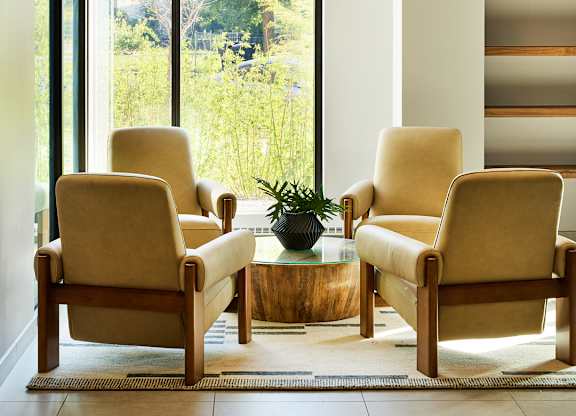 Seating area with upholstered chairs and sculptural chandelier at Thrive Exchange Apartments, Chicago, IL 60617
