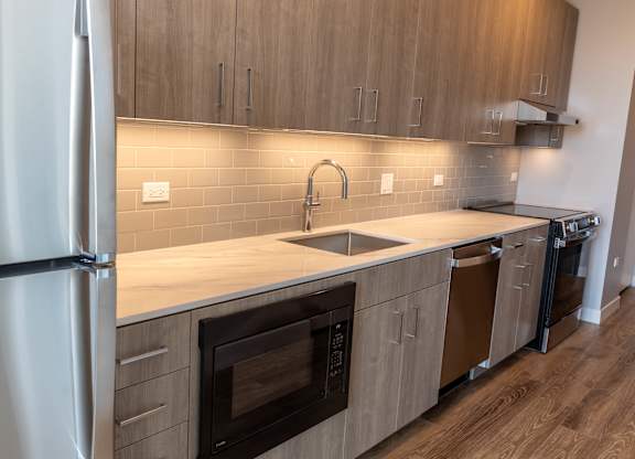 Modern kitchen with under cabinet lighting at Thrive Exchange Apartments, Chicago