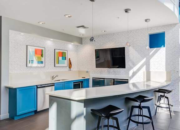 A kitchen with a white counter top and blue cabinets.