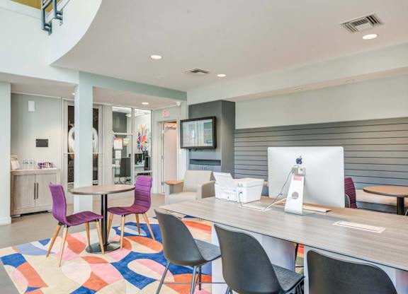 A modern office space with a colorful rug and a wooden table.